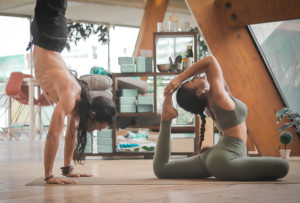 Yoga für Anfänger. Ein Mann und eine Frau machen Yoga Übungen in einem Studio.